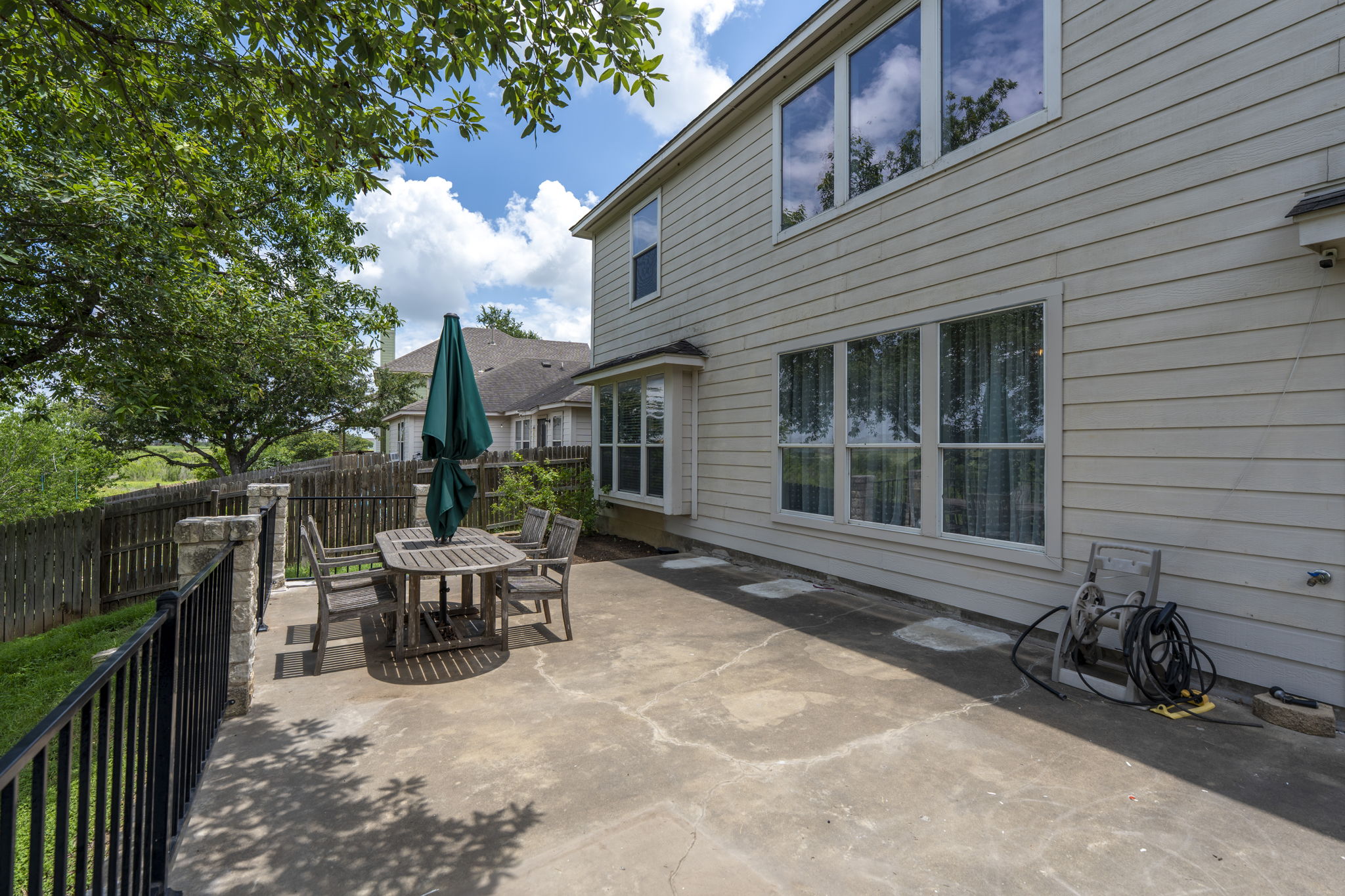 454 Fall Circle Kyle, TX 78640 - Photo 38 of 39 A spacious concrete patio awaits outdoor dining and entertaining, framed by mature trees and a private fenced yard.