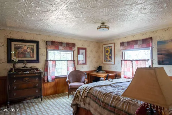 a bedroom with two beds and a dresser next to a window