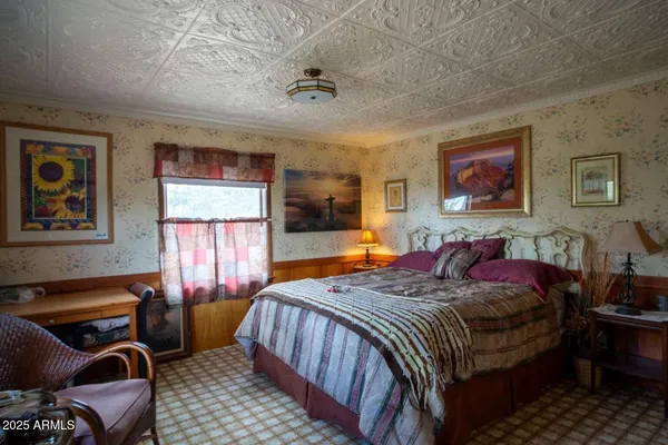 a bedroom with a bed a couch and large window