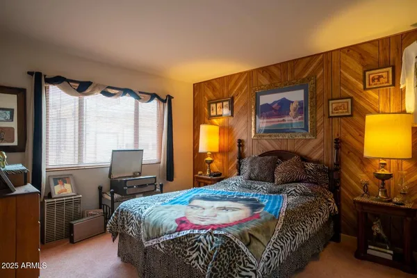 a bedroom with a bed and dresser with mirror