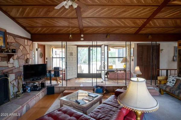 a living room with furniture a flat screen tv and a large window