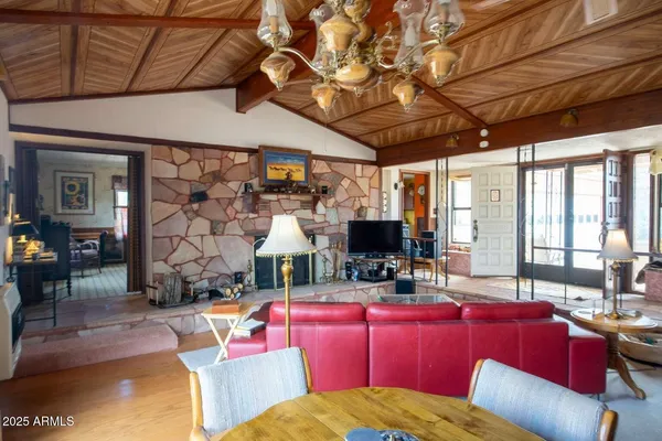 a living room with furniture a flat screen tv and floor to ceiling window