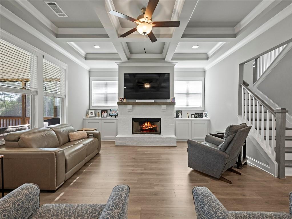 857 Champagne Lane Hoschton, GA 30548 - Photo 11 of 73 a living room with furniture a flat screen tv and a fireplace