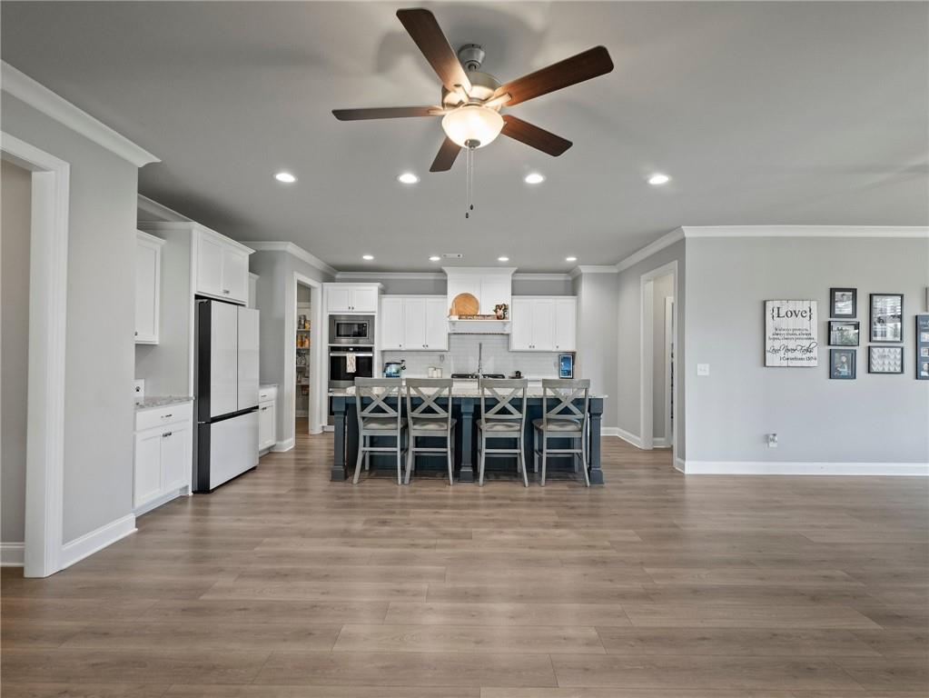857 Champagne Lane Hoschton, GA 30548 - Photo 14 of 73 a kitchen with stainless steel appliances kitchen island granite countertop a refrigerator and a stove top oven