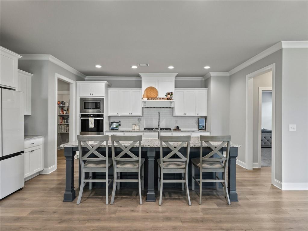 857 Champagne Lane Hoschton, GA 30548 - Photo 15 of 73 a view of a dining room with furniture wooden floor and stainless steel appliances