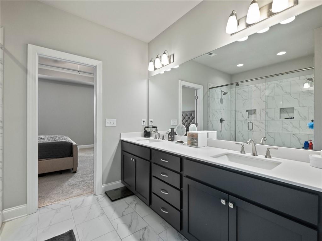857 Champagne Lane Hoschton, GA 30548 - Photo 33 of 73 a en suite bathroom with a double vanity sink a mirror and a bathtub