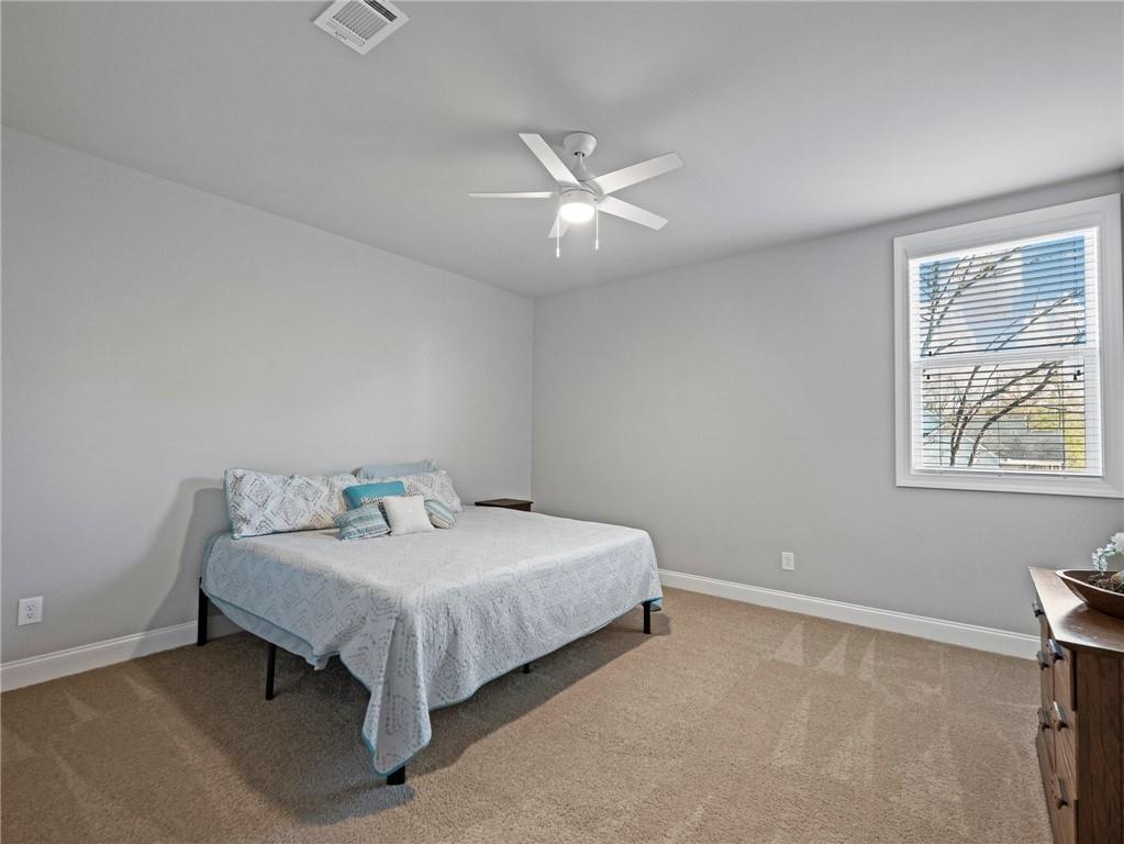 857 Champagne Lane Hoschton, GA 30548 - Photo 52 of 73 a bed sitting in a bedroom next to a window