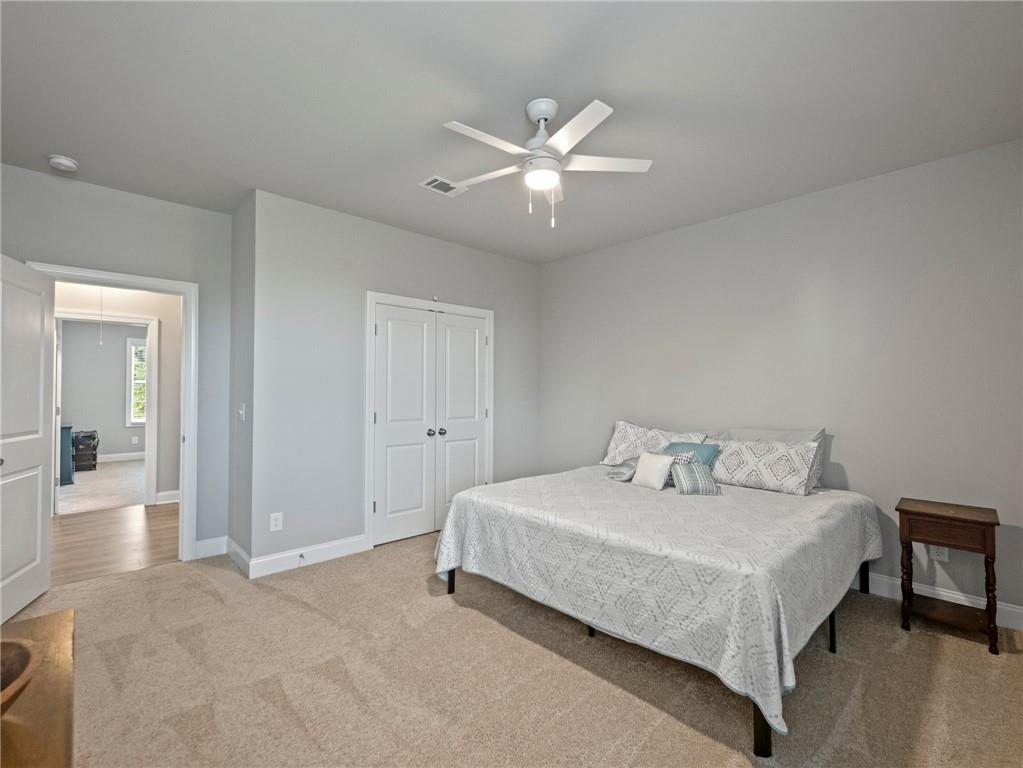 857 Champagne Lane Hoschton, GA 30548 - Photo 53 of 73 a bedroom with a bed and a chandelier