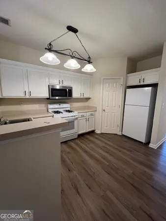a kitchen with a white cabinets and white appliances