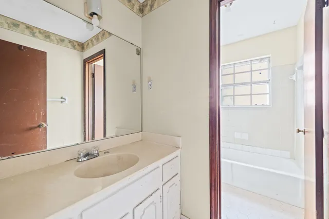 a bathroom with a granite countertop sink and a mirror