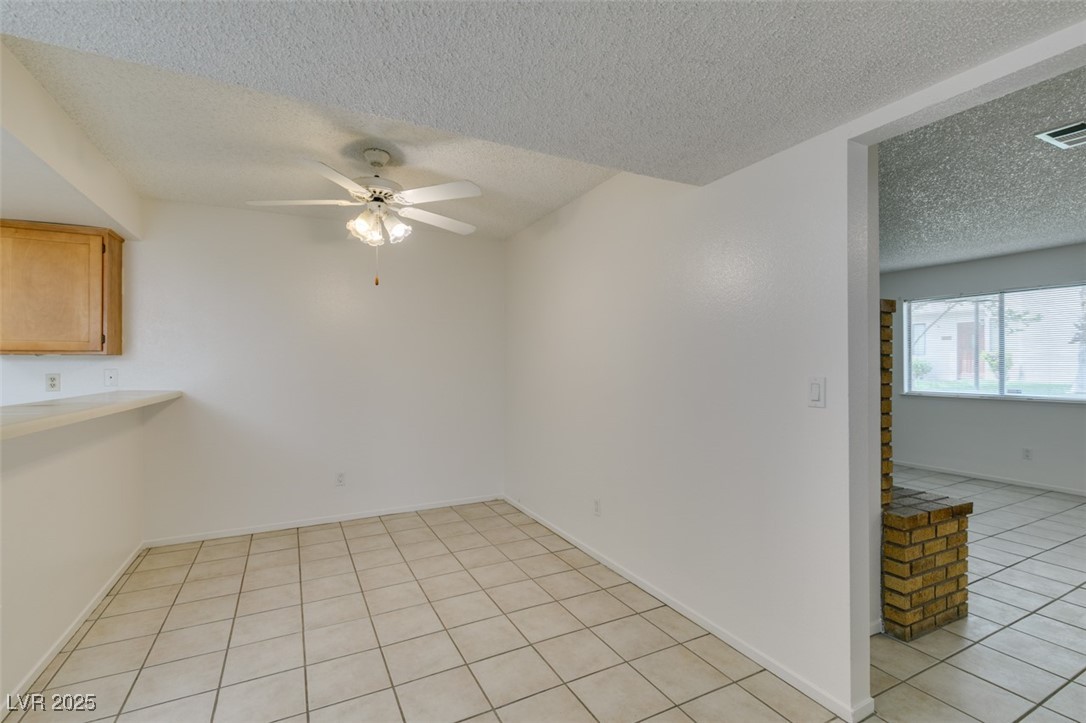 2681 Ruthe Duarte Avenue Las Vegas, NV 89121 - Photo 16 of 43 Unfurnished dining area with a textured ceiling, light tile patterned floors, a ceiling fan, and visible vents