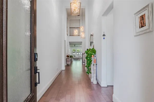 a view of a hallway with wooden floor and a potted plant