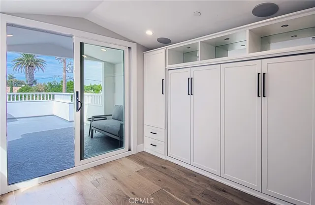 a view of a hallway with wooden floor and a bathroom
