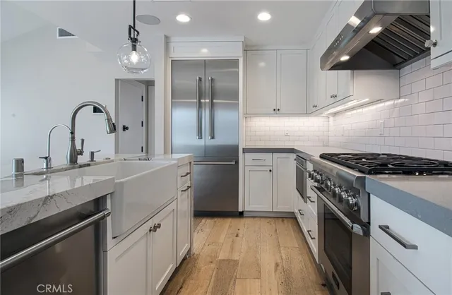 a kitchen with granite countertop a sink cabinets and stainless steel appliances