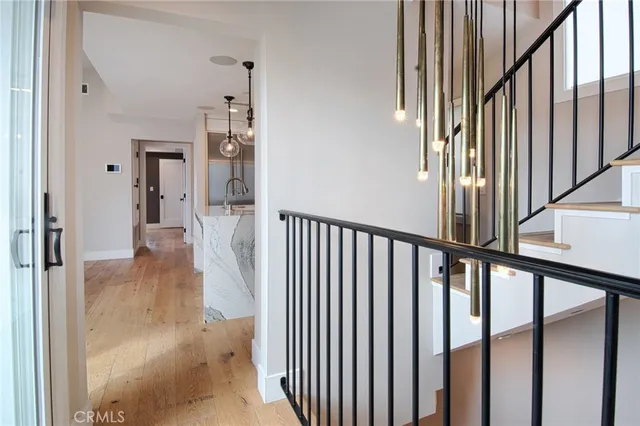 a view of a hallway with wooden floor and staircase