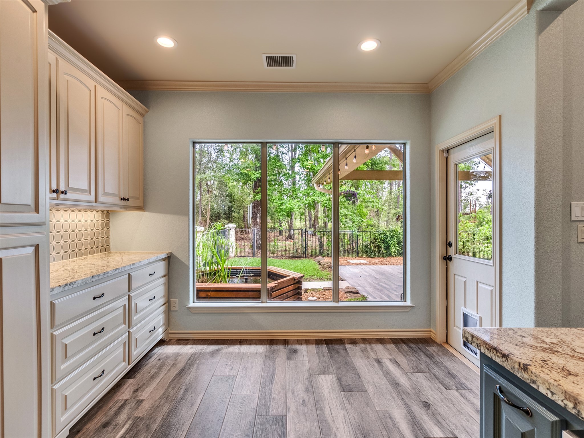 18005 Cindy Lane Conroe, TX 77302 - Photo 22 of 49 A large window and door provide access to a lush backyard, offering a seamless indoor-outdoor connection.