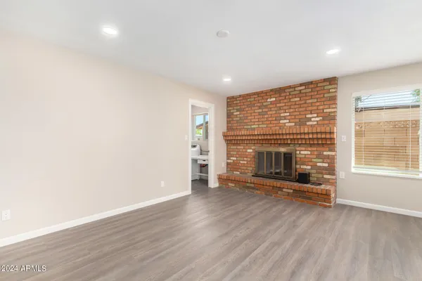 a kitchen with stainless steel appliances kitchen island granite countertop a refrigerator a stove and a sink with wooden floor