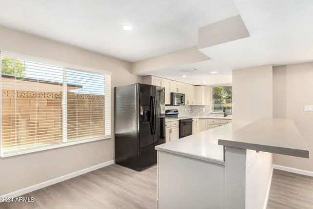 a large white kitchen with a large window