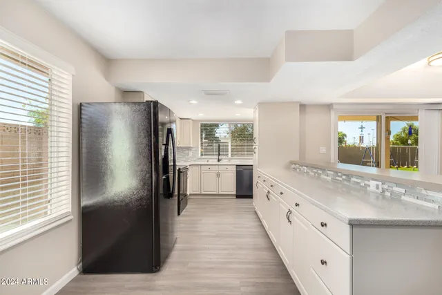 a large bathroom with a granite countertop double vanity sink a mirror and a shower