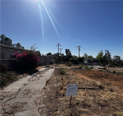 a view of a dry yard with wooden fence