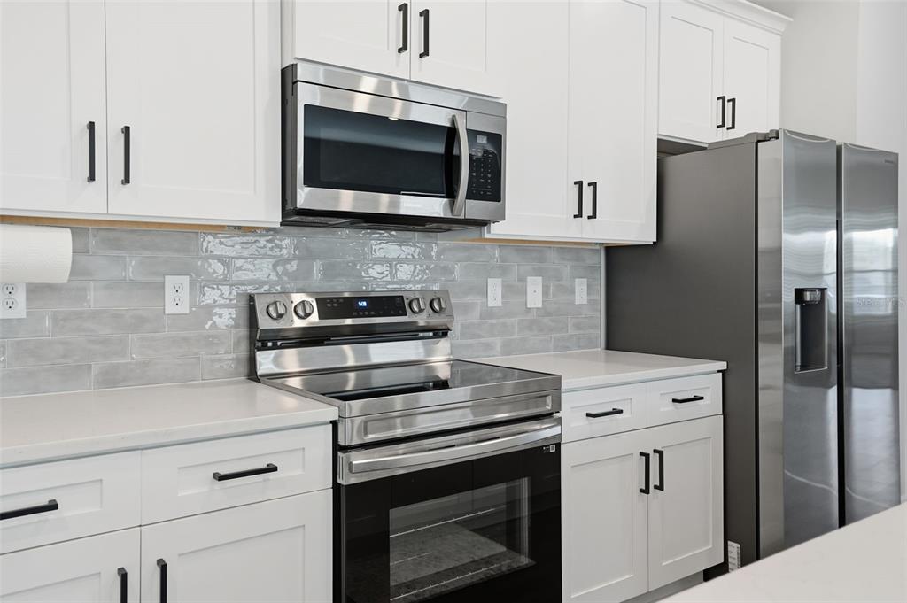 8549 Southwest 129 Lane Ocala, FL 34473 - Photo 12 of 31 a kitchen with cabinets stainless steel appliances and a wooden floor