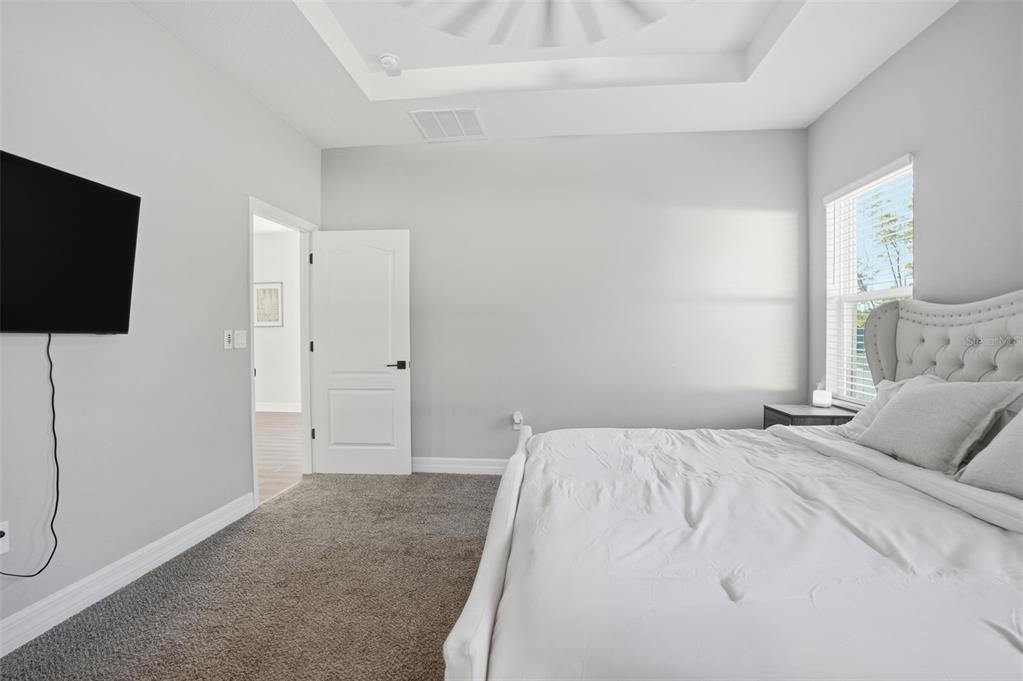 8549 Southwest 129 Lane Ocala, FL 34473 - Photo 21 of 31 a bedroom with a bed and a flat screen tv