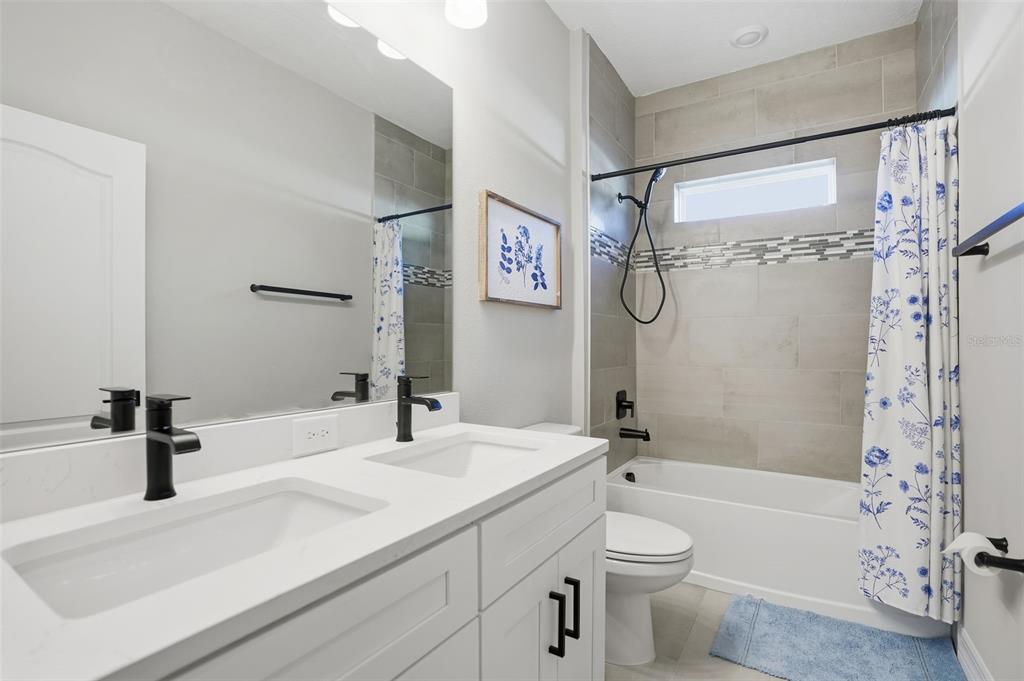 8549 Southwest 129 Lane Ocala, FL 34473 - Photo 24 of 31 a bathroom with a granite countertop sink toilet a shower and a mirror