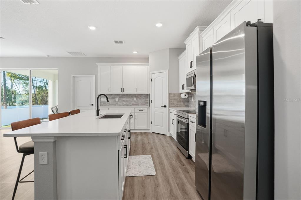 8549 Southwest 129 Lane Ocala, FL 34473 - Photo 9 of 31 a kitchen with stainless steel appliances a refrigerator sink and stove