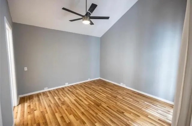 a view of a big room with wooden floor and a ceiling fan