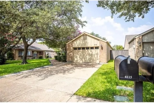 a view of a house with a yard and table and chairs under an umbrella