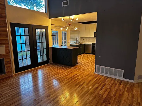 a view of a living room with wooden floor and furniture