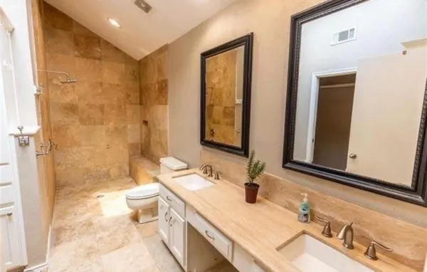 a bathroom with a granite countertop sink a toilet and shower