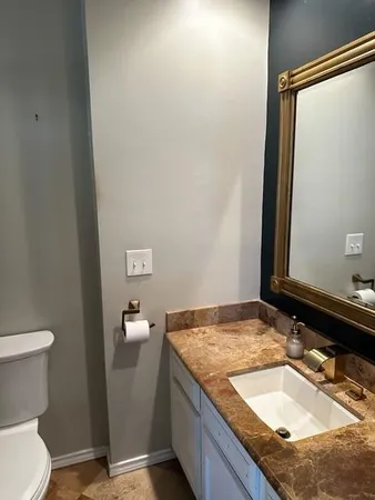 a bathroom with a granite countertop sink and a mirror
