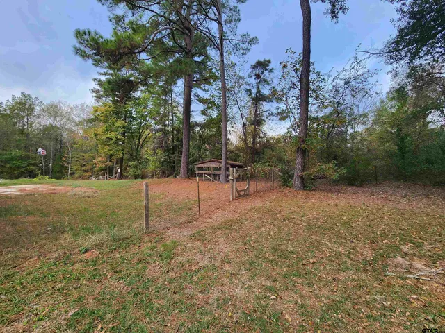 a backyard of a house with childrens swings and slides