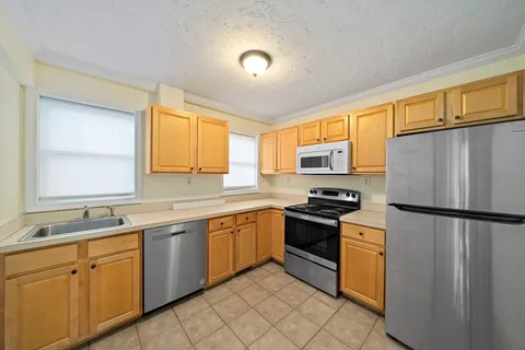 a kitchen with stainless steel appliances granite countertop a refrigerator sink and stove