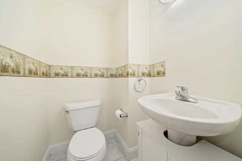 a bathroom with a toilet a sink and mirror