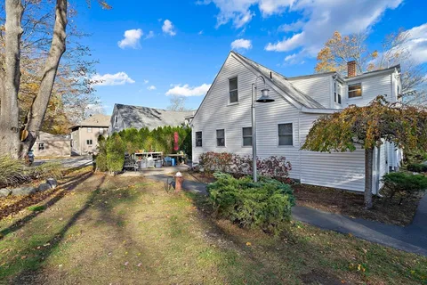 a view of a house with backyard and sitting area