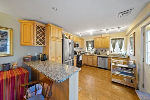 a kitchen with stainless steel appliances granite countertop a sink refrigerator and cabinets