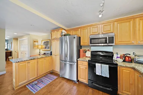 a kitchen with stainless steel appliances granite countertop a refrigerator stove top oven and sink