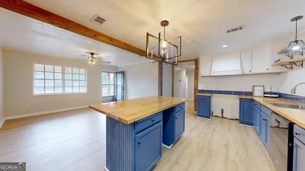 a kitchen with stainless steel appliances granite countertop a sink a stove top oven a counter space and cabinets