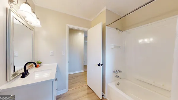 a bathroom with a tub sink and mirror