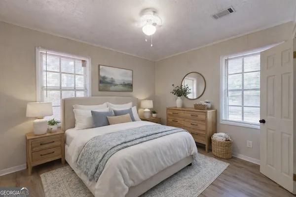 a bedroom with a bed a mirror on dresser and a window