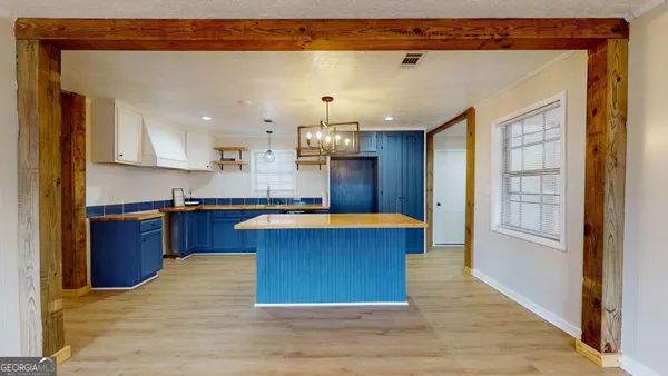 a kitchen with kitchen island granite countertop wooden floors and a sink