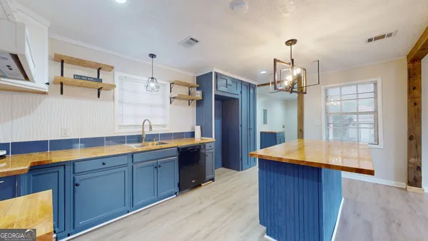 a kitchen with stainless steel appliances granite countertop a sink a stove and a wooden floors