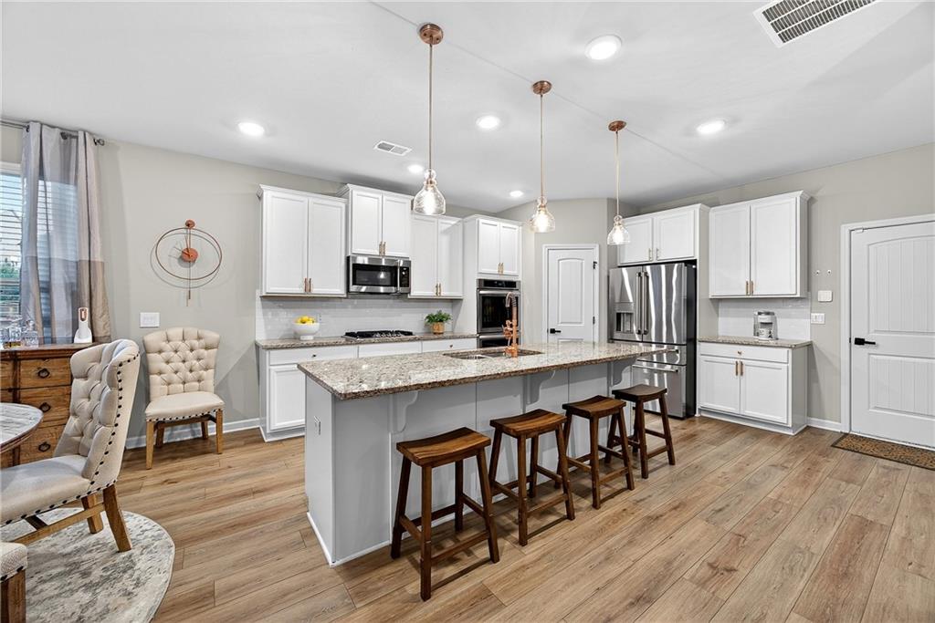 4863 Sultana Way Atlanta, GA 30331 - Photo 11 of 42 a large kitchen with cabinets wooden floor and stainless steel appliances