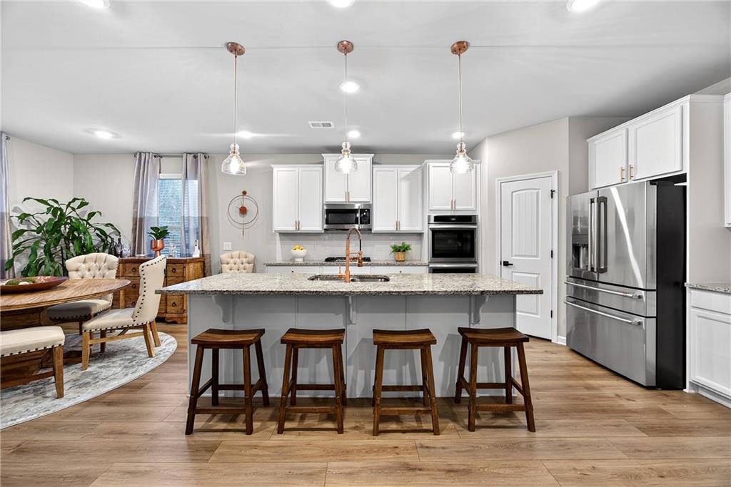 4863 Sultana Way Atlanta, GA 30331 - Photo 12 of 42 a kitchen with refrigerator a sink and chairs