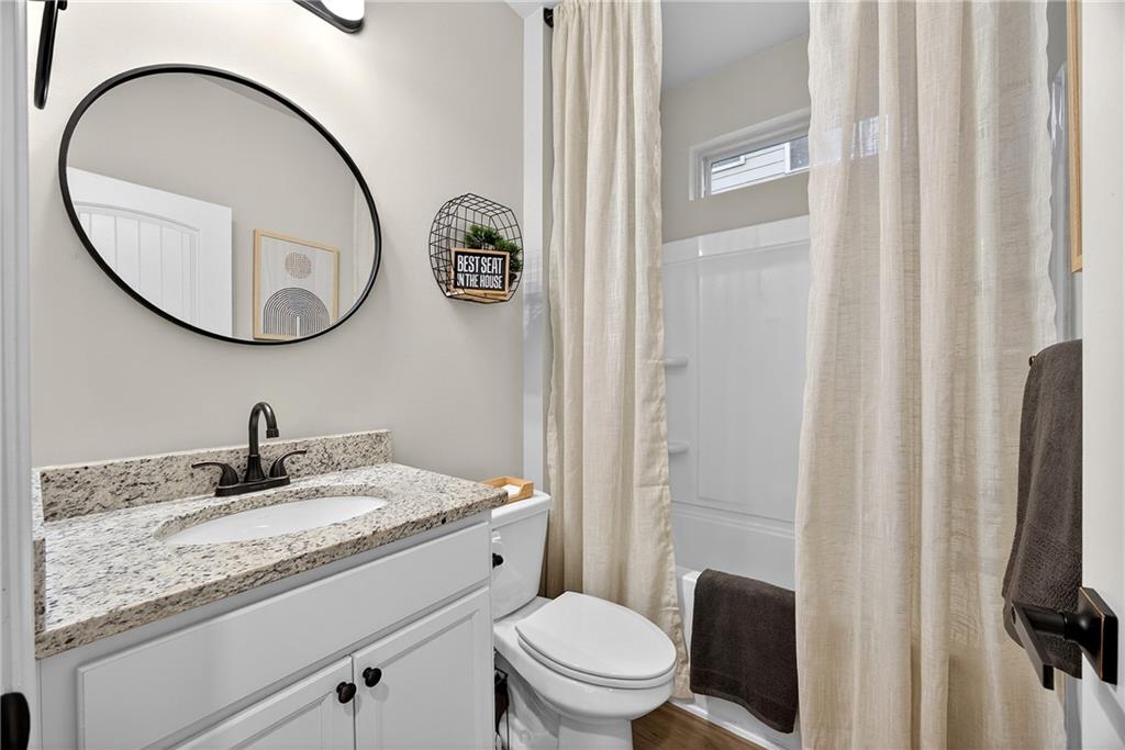 4863 Sultana Way Atlanta, GA 30331 - Photo 14 of 42 a bathroom with a granite countertop toilet sink and mirror