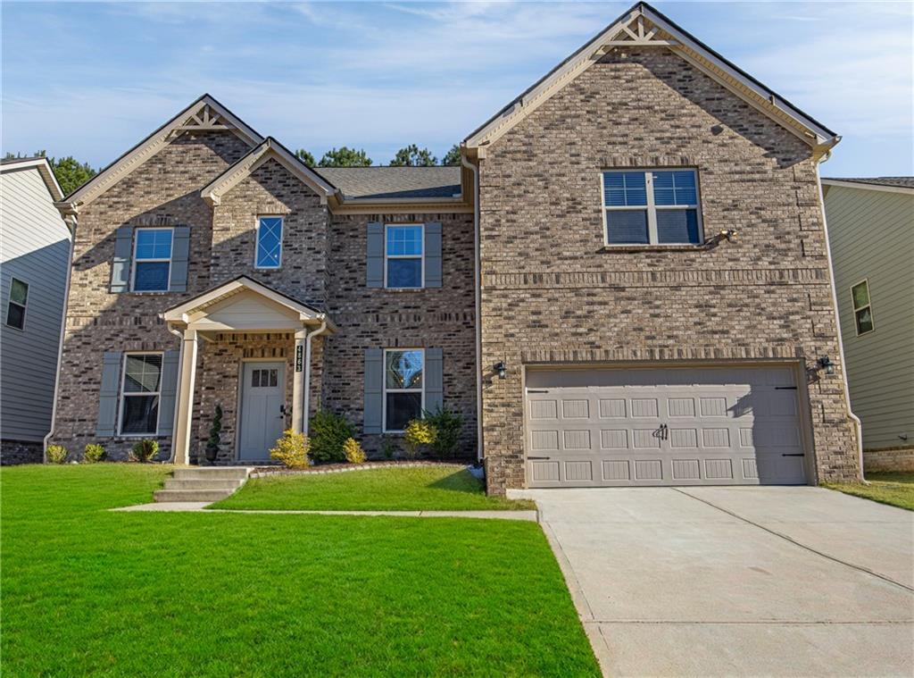 4863 Sultana Way Atlanta, GA 30331 - Photo 2 of 42 a front view of a house with a yard and garage