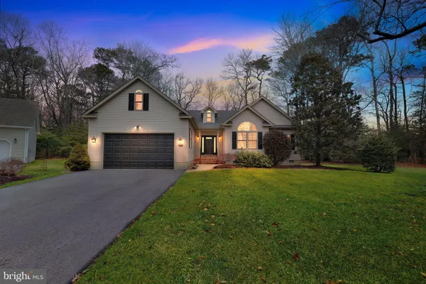 a front view of a house with yard and green space