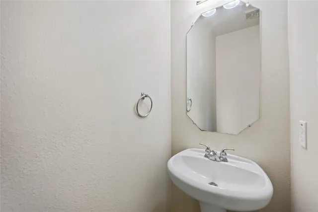 an empty room with wooden floor chandelier fan and windows